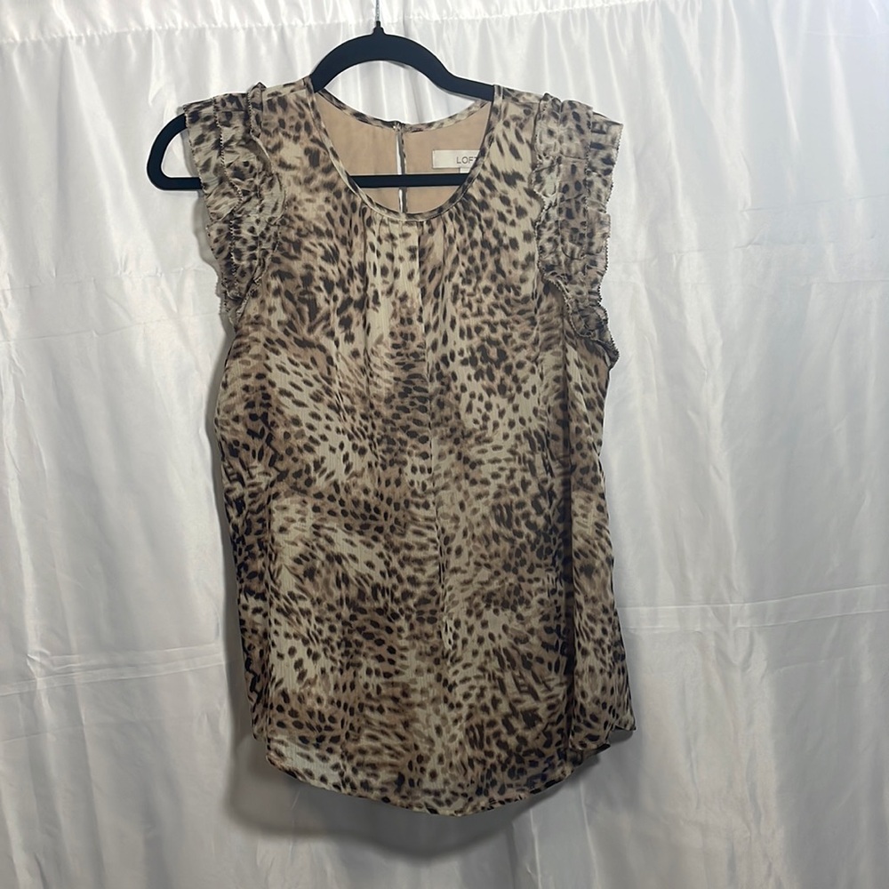 Leopard print lined sleeveless shell. Button neck and ruffle sleeve.